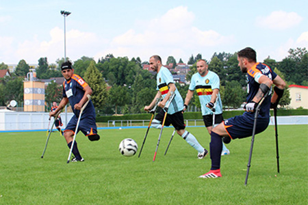 4 Amputierten Fußballspieler auf Krücken beim Spiel auf einem Rasenplatz