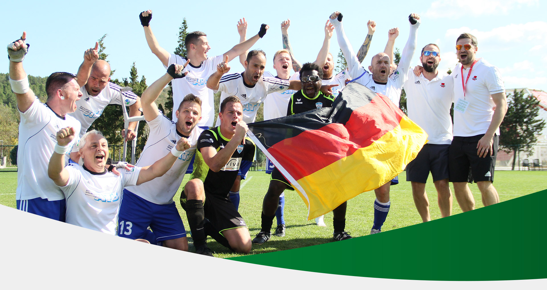 Kopfbild: jubelnde Amputierten Fußballmannschaft in einem Stadion. Die beiden Torhüter halten eine Deutschlandfahne hoch