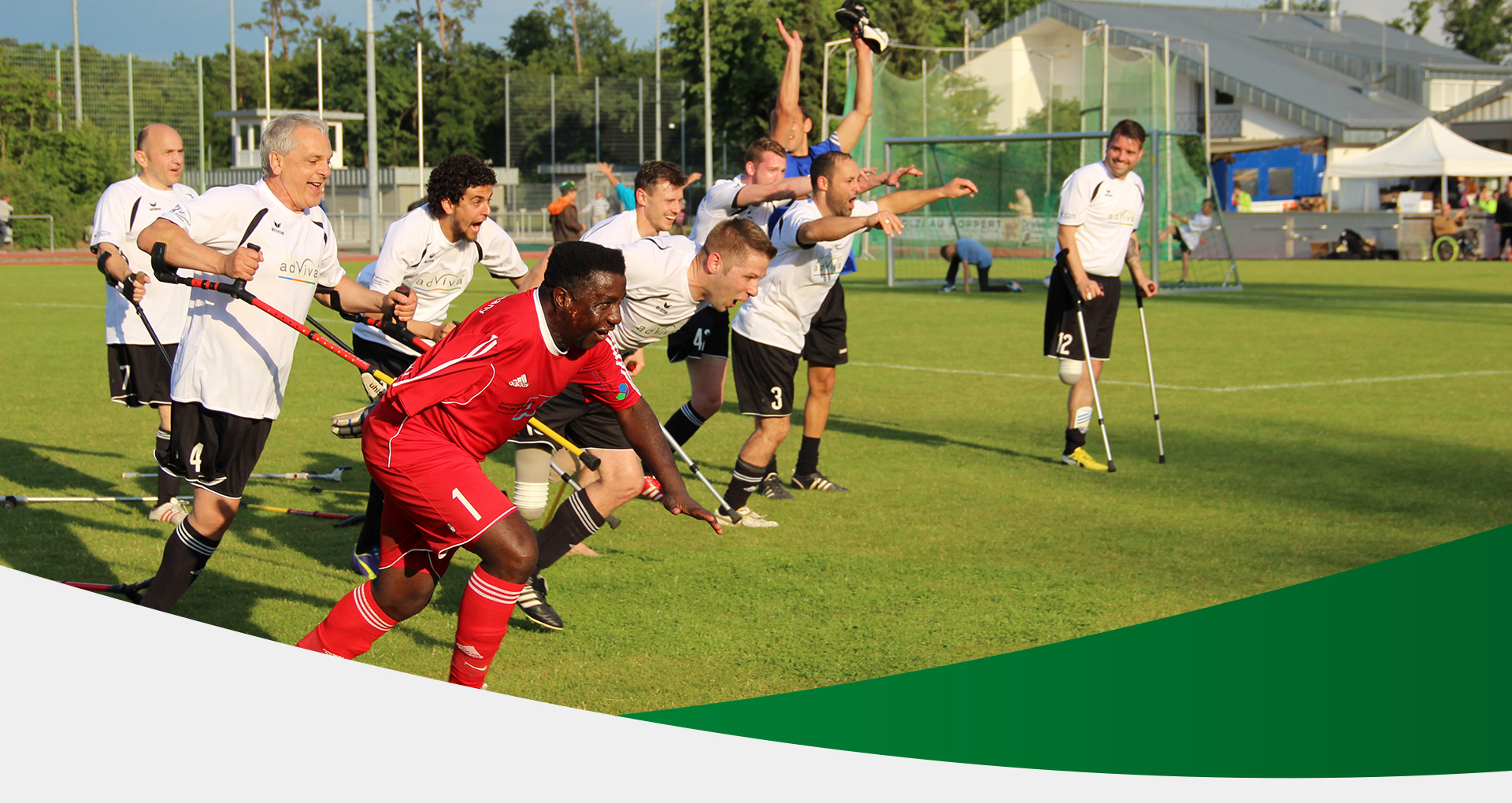 Kopfbild: Amputierten Fußballmannschaft beim Torjubel auf einem Rasenplatz