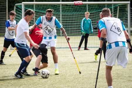 Drei Amputierten-Fußballer auf Krücken im Kampf um den Ball. Zwei weitere Spieler schauen zu.