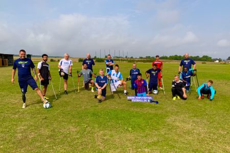 16 Amputierten-Fußballer beim Gruppenbild auf einem Rasenplatz
